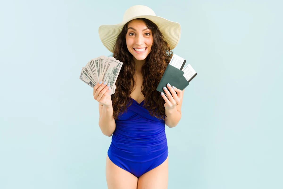 Une femme qui tient des billets d'argent dans une main et des passeports avec des billets d'avion dans l'autre